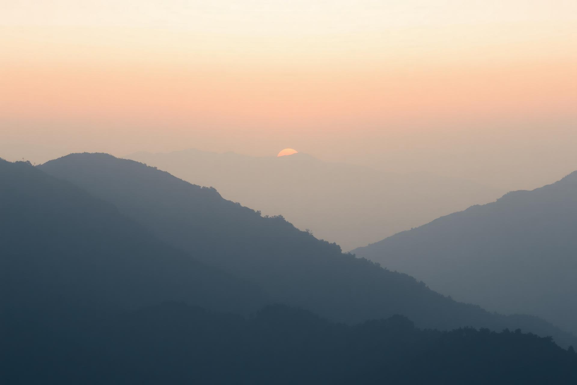 Hazy sunrise over distant mountains